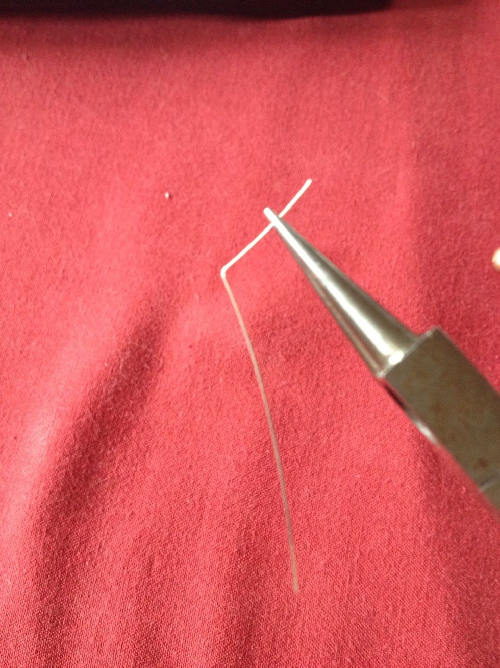Make a l-shaped bend in a piece of wire with your pliers.