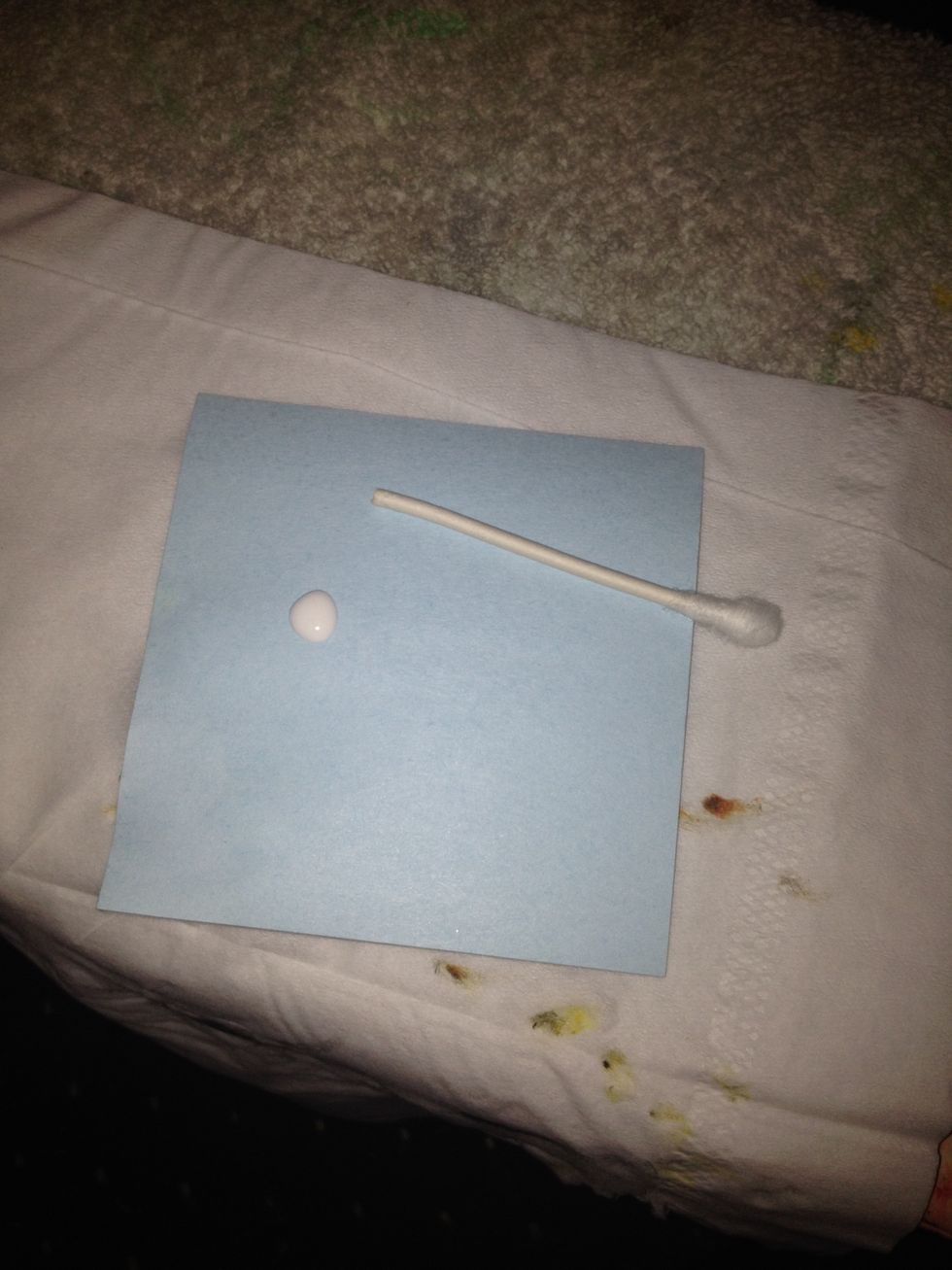 Make a little nail color palette with a notepad paper, drop some white color onto it and cut off a tip from your cue tip for the next step.