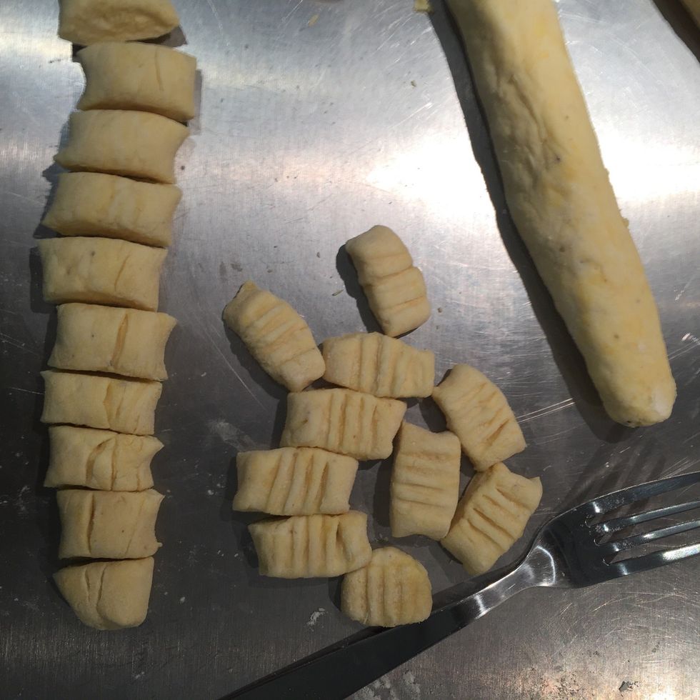 Make a log and cut it into 4 parts. Roll them into '2 cm' thickness ropes. Cut and make indents with a fork.