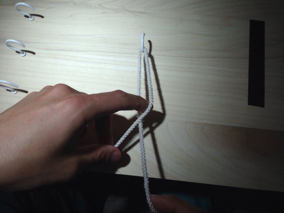 Make a loop with the index finger. Note that the suture now crosses at your finger and not by the hook.