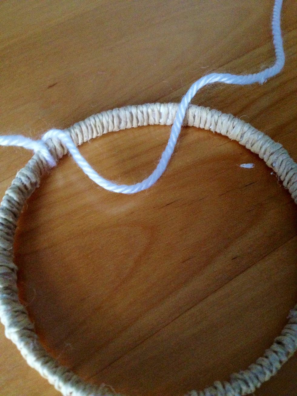 Make a loop with the string that lies on top of the ring like so.