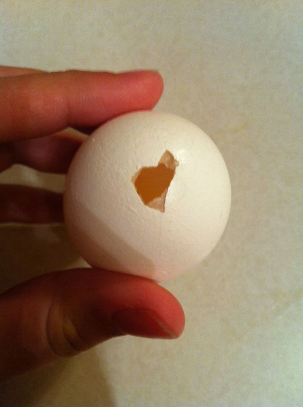 Make a small hole into the egg with a needle... Turn the egg upside down and wiggle the yoke out so the egg is hollow!