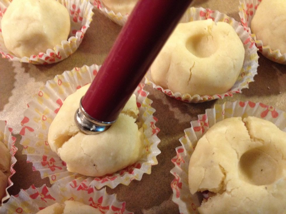 Make a small hollow into every cookie using your fingertip or the round back end of a spoon.