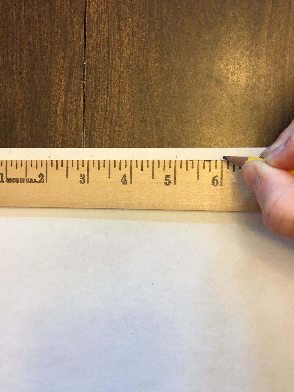 Make a small light pencil mark at each 1" interval -- for example 1, 2, 3, etc all the way across the paper.