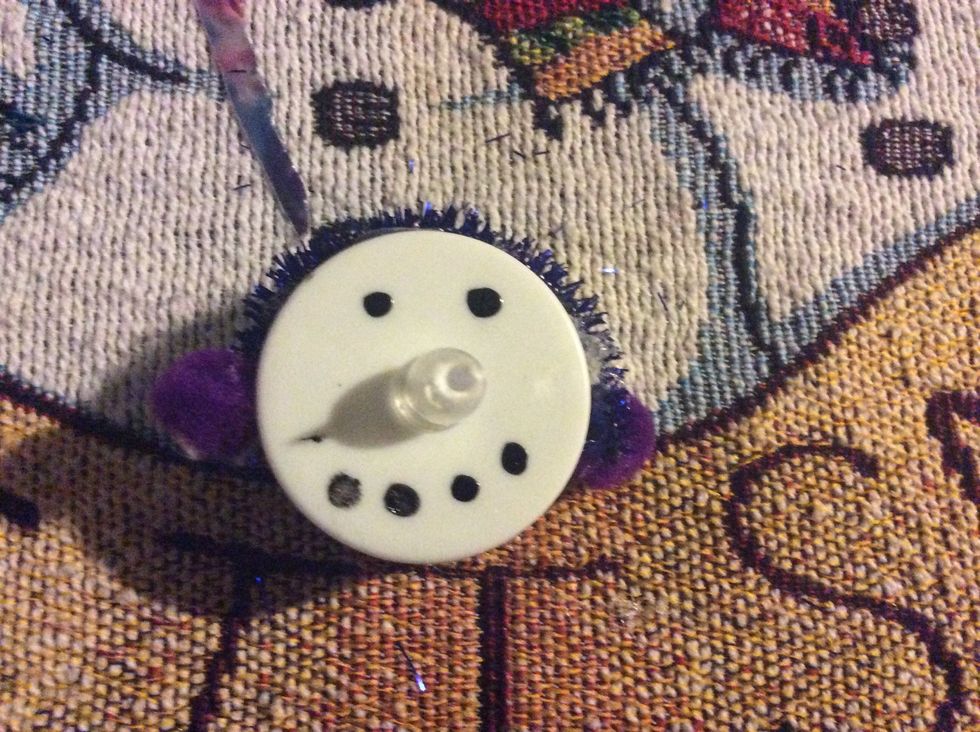 Make a strip of glue on top of the tea light. Then put on the pipe cleaner, then glue on pom