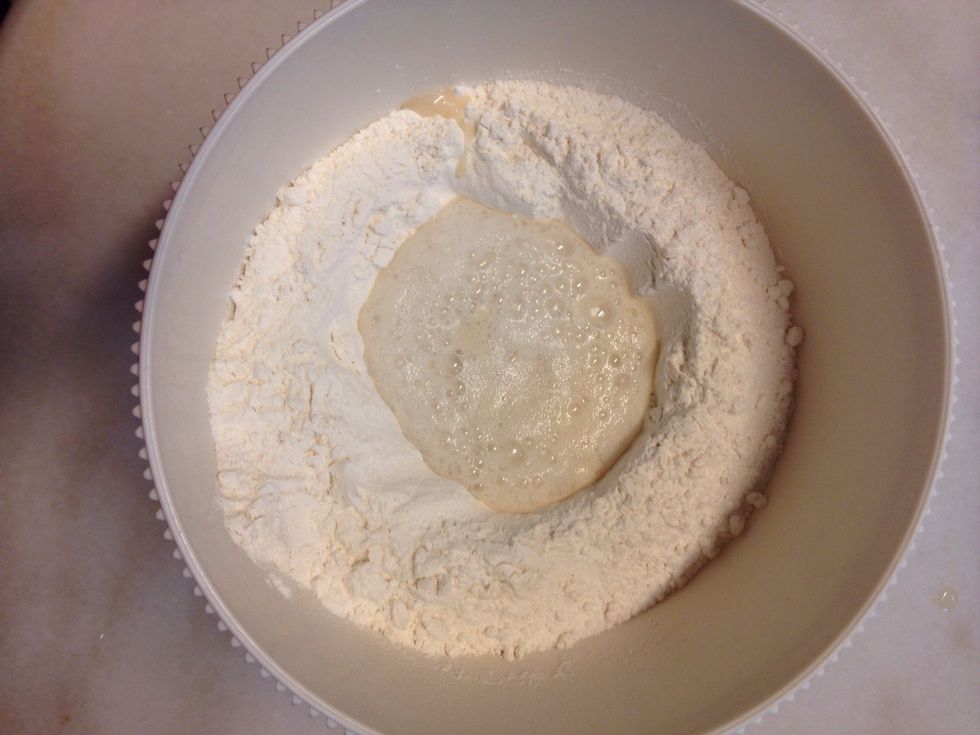 Make a well in the middle then pour in the yeast mixture and half of the remaining warm water. Mix and stir in the rest of the water as needed.