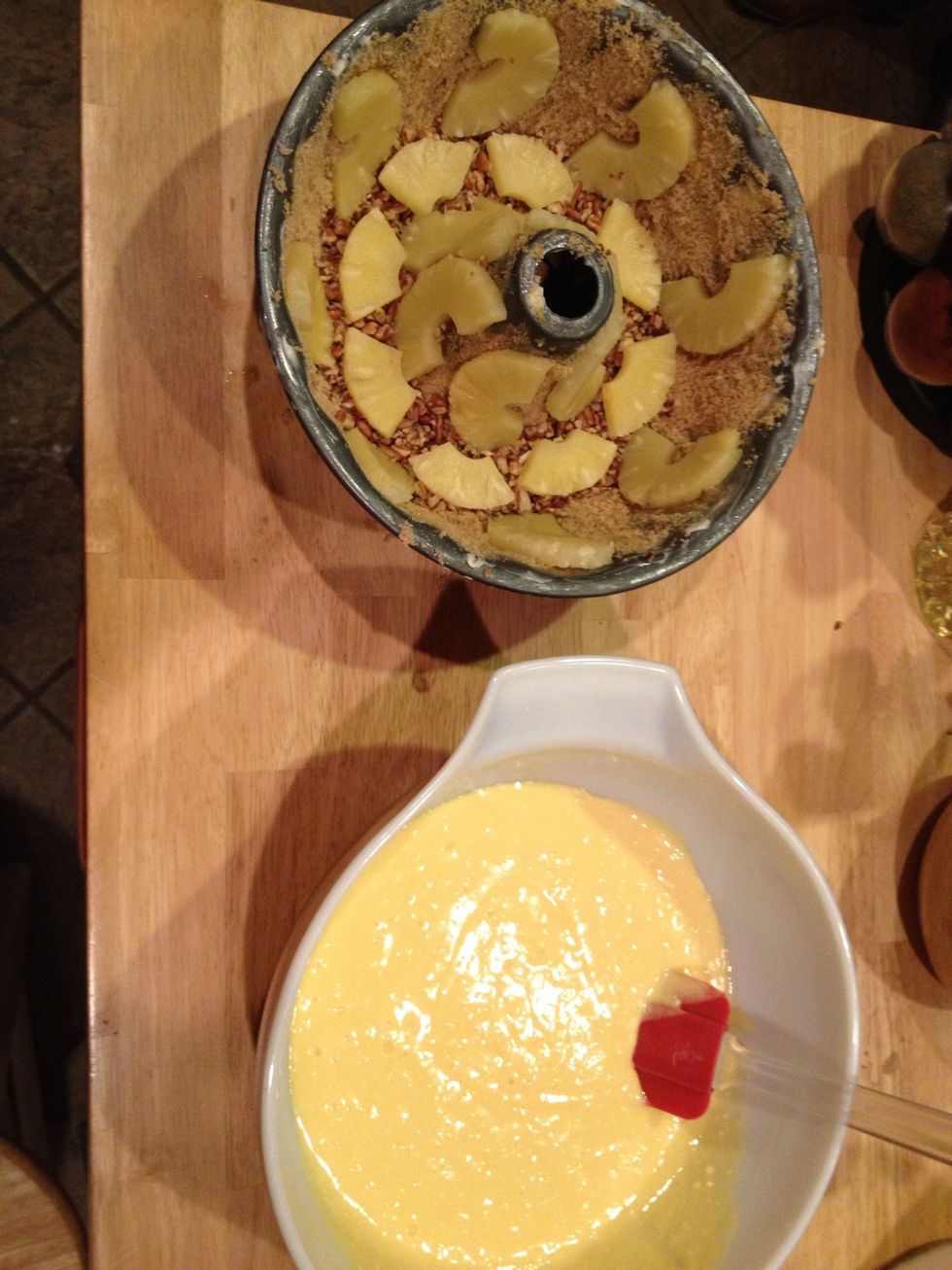 Make cake mix to specifications on box substituting pineapple juice for water. Pour into bundt pan. Bake according to temperature and time duration on box.