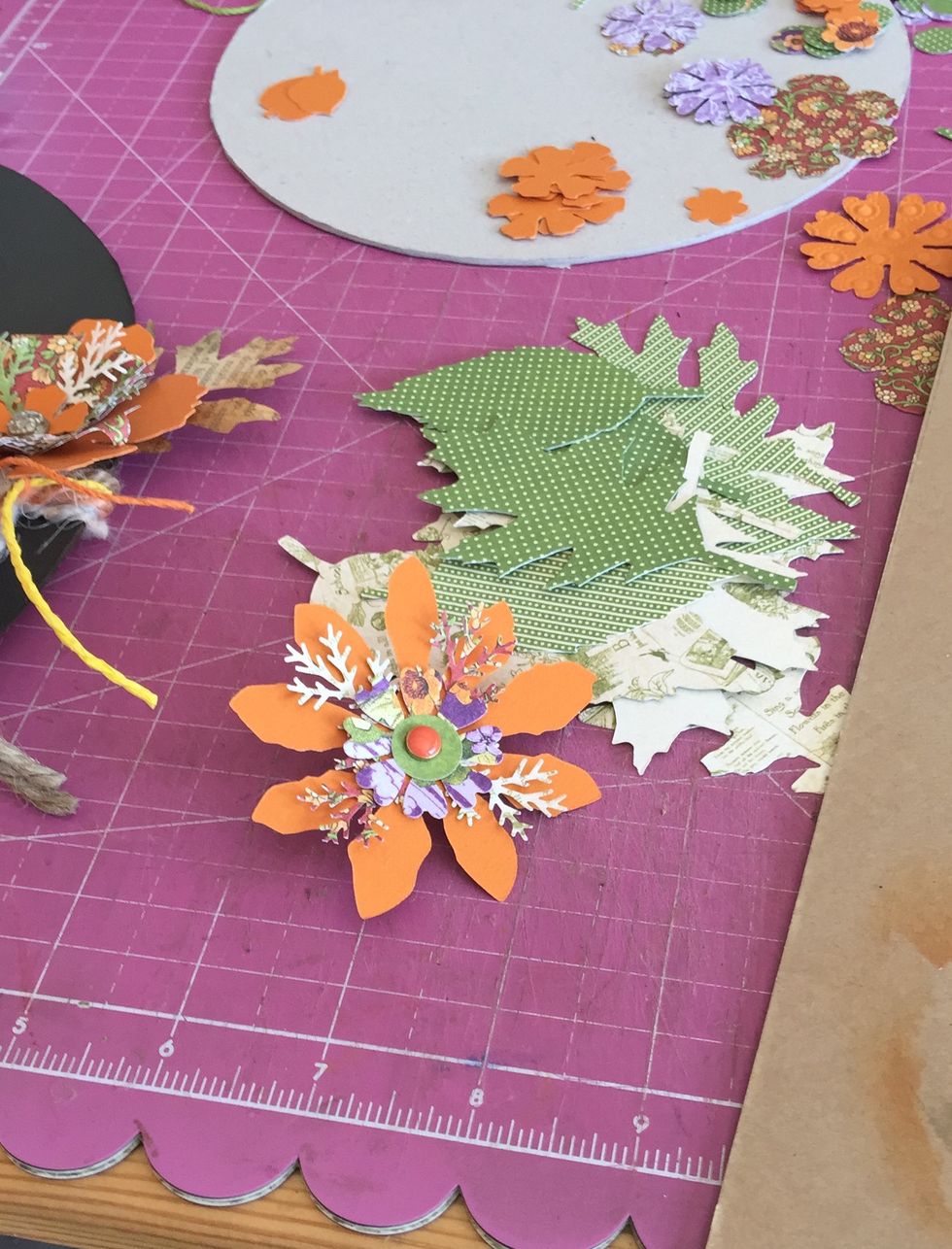 Make flowers using several elements and a brad and glue on the wreath as you like.