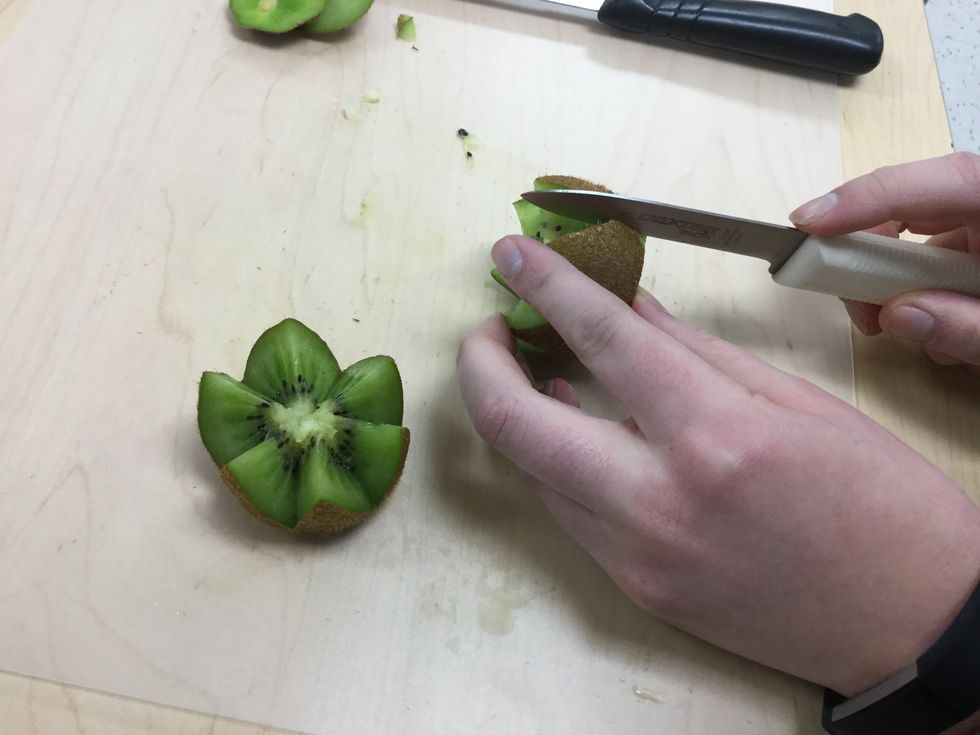 Make incisions into the skin from top to bottom of the kiwi between the points (but don\u2019t cut very deep into flesh)