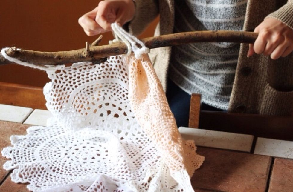 Make loops at the top of the curtain with rope or yarn. Thread the loops onto the wooden stick.