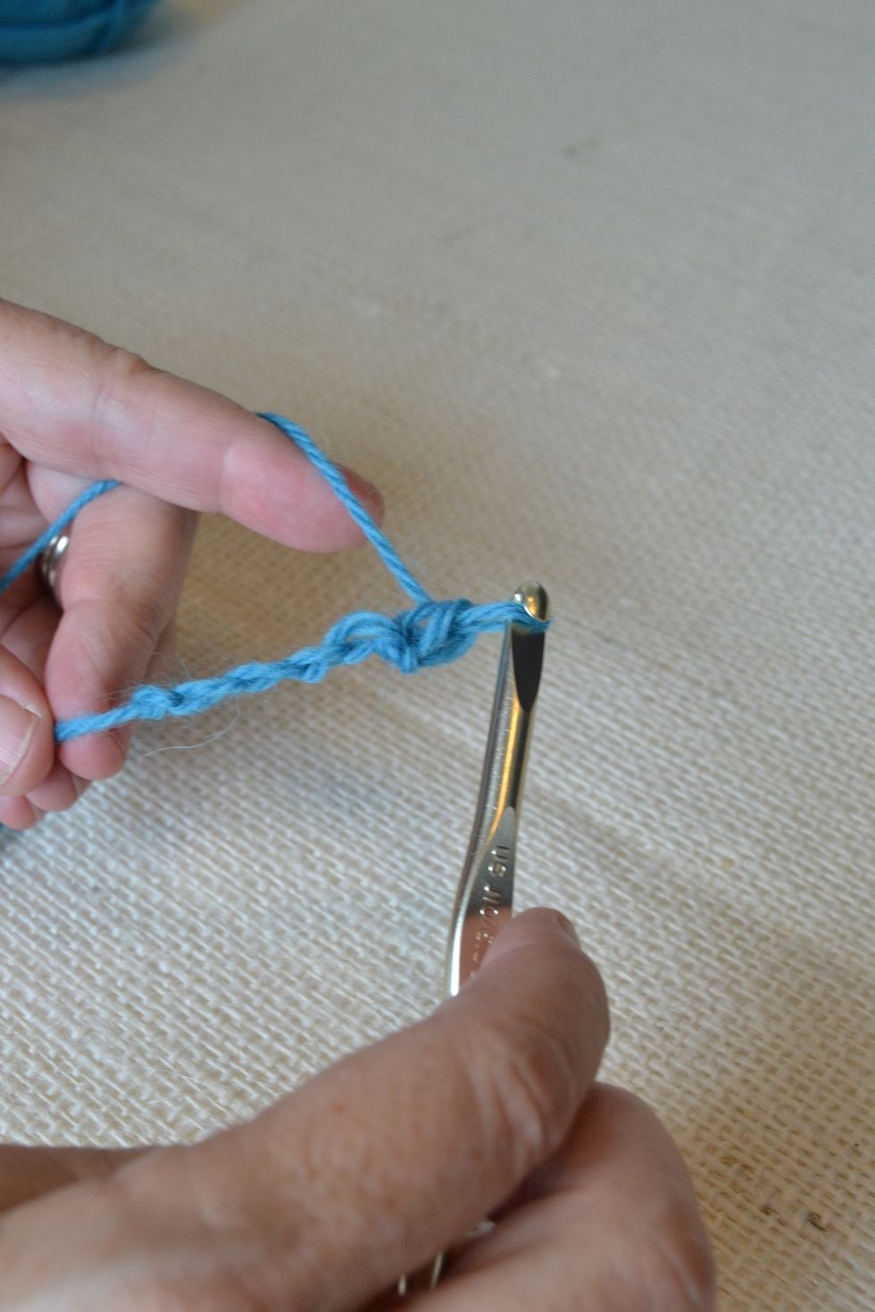 Make one extra chain stitch at the end (your turning chain), and then turn your piece from right to left. Insert the hook under the first V (skipping the one you just made) and repeat steps.
