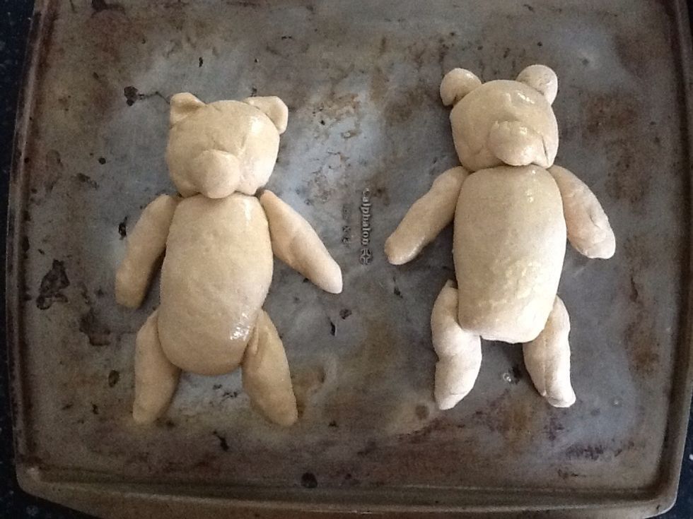 Make second bear from remaining dough. Place both bears on a baking sheet. Butter dough or spray with nonstick cooking spray. Cover with plastic wrap and allow to rise 30 to 90 minutes.