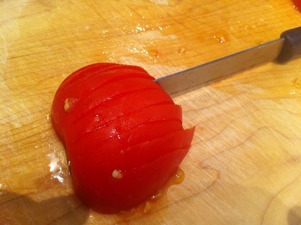 Make slices through the tomato, look closely at the pic and you can see them. Don't cut all the way through stem end as this holds it altogether!