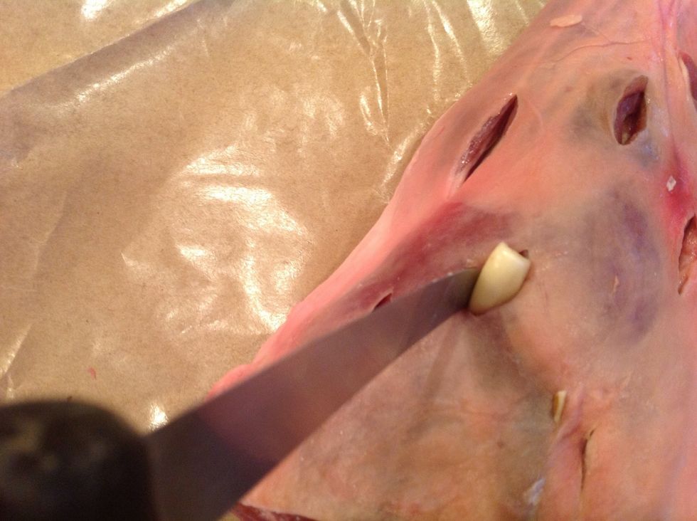 Make small slits in the leg to insert cloves