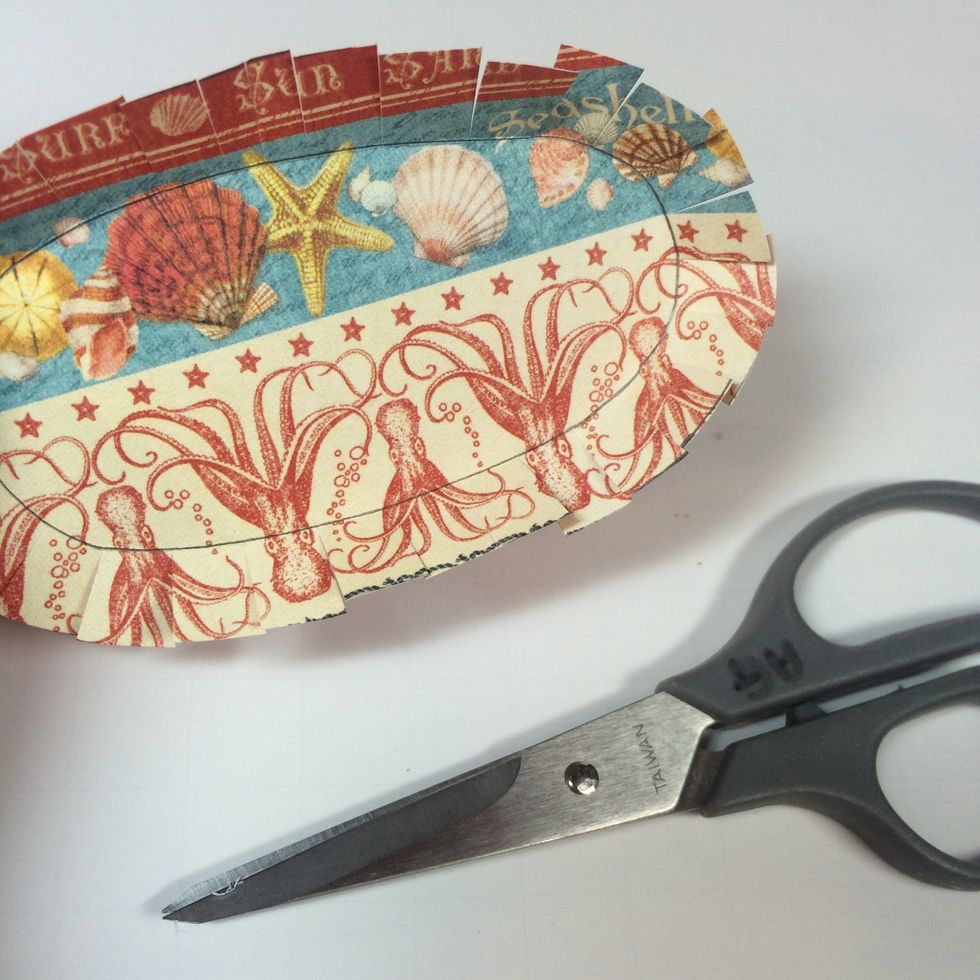 Make small snips with scissors all the way around, cutting just to the inner oval as shown.