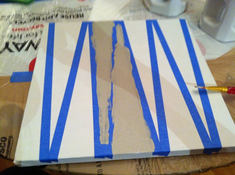 Make sure tape is firmly on canvas and begin to paint your second color