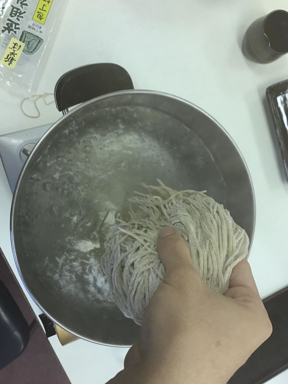 Make sure that the water is boiling. After checking, place the cut noodles into the pot.