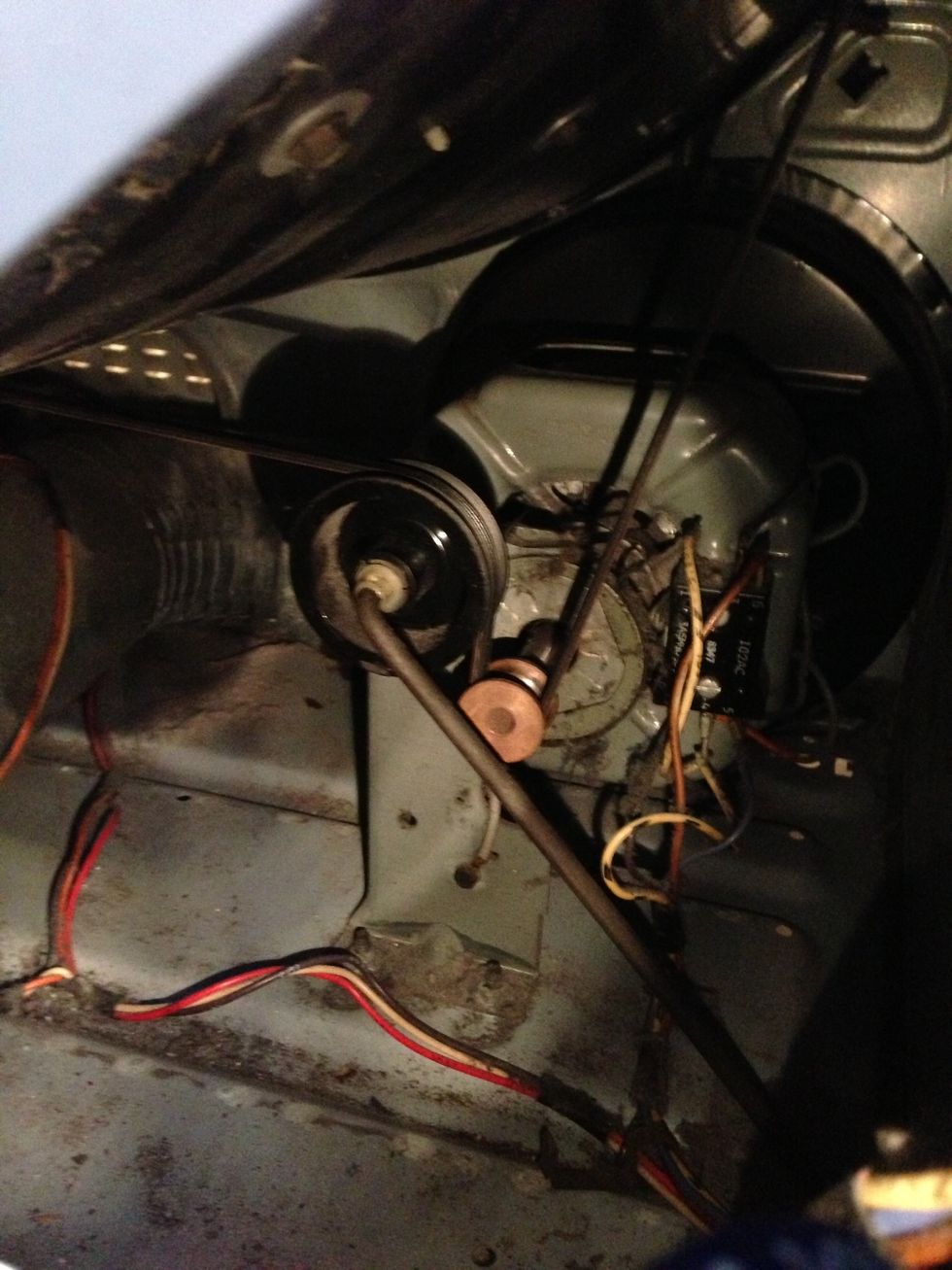 Make sure the belt is on the pulley correctly. This is a view through a little screw-off panel on the back of the machine: hard to see but the belt comes over the big pulley and under the motor shaft.