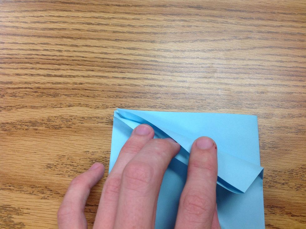 Make sure the open side is pointing up, then grab the corner and fold it inward following the middle crease line as your guide. You will do this fold 3 more times, for the remaining sides.