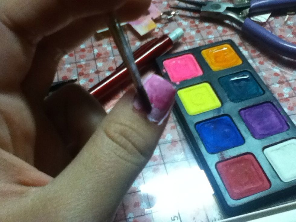 Make sure the paint is dry then dip you paint brush in the water then into the watercolor & paint all over the nail.