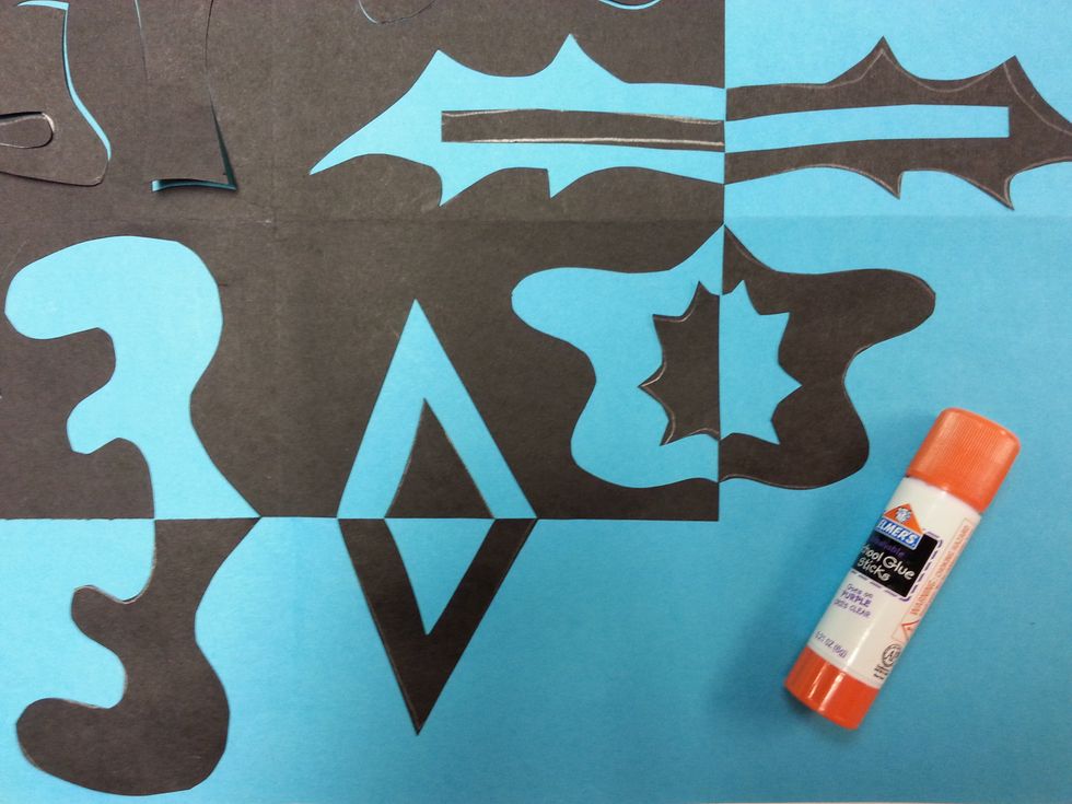 Make sure the straight edge of the shape lines up where the straight edge of the paper would be. (This is the LINE OF SYMMETRY.) The smaller shapes should be on the line of symmetry too. Glue.