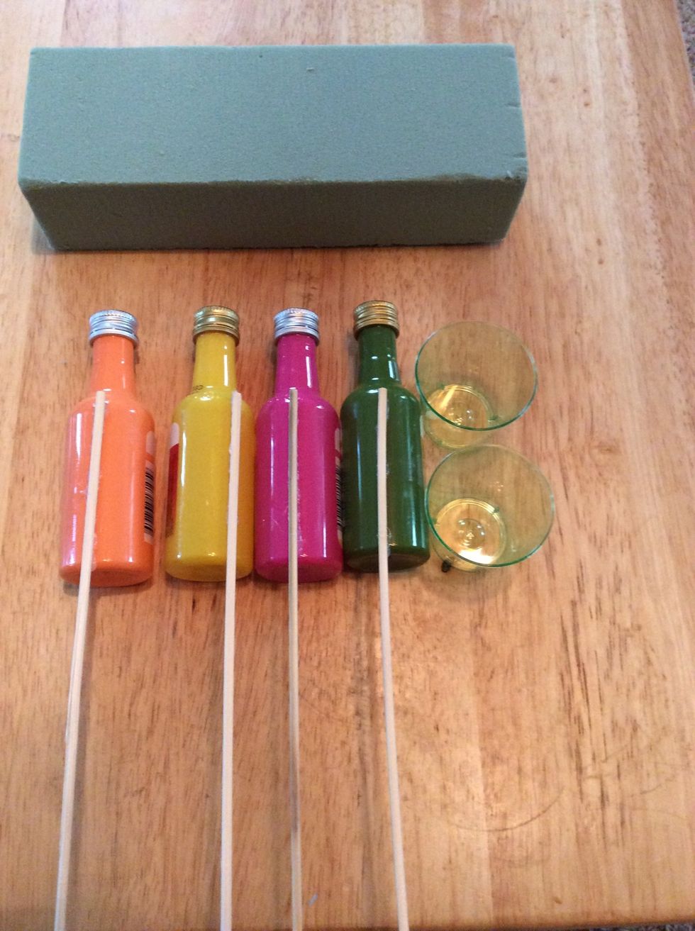 Make sure you've let your glue gun heat up for the appropriate amount of time (follow instructions for your tool.) Glue wooden skewers to the backs of the mini liquor bottles. Hold until glue dries.