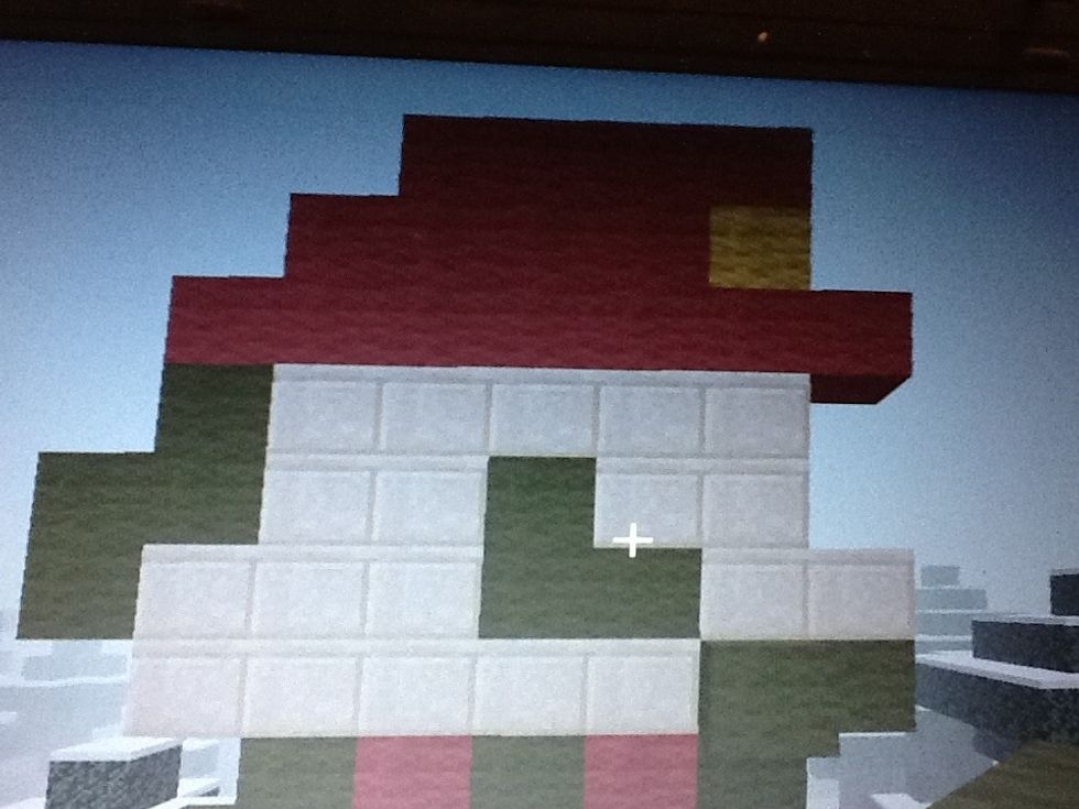 Make the head with green wool, smooth sandstone, red wool, and yellow wool