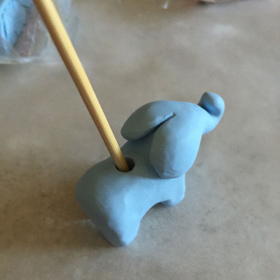 Make the hole bigger by moving the skewer around slowly on each side.