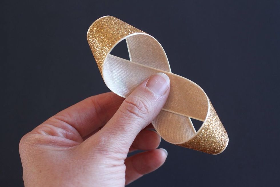 Make the same type of loop with the other end of the ribbon, overlapping both ends as they meet. Staple the center of your figure 8 to hold it all together. Repeat w/ all five of your longer ribbons.