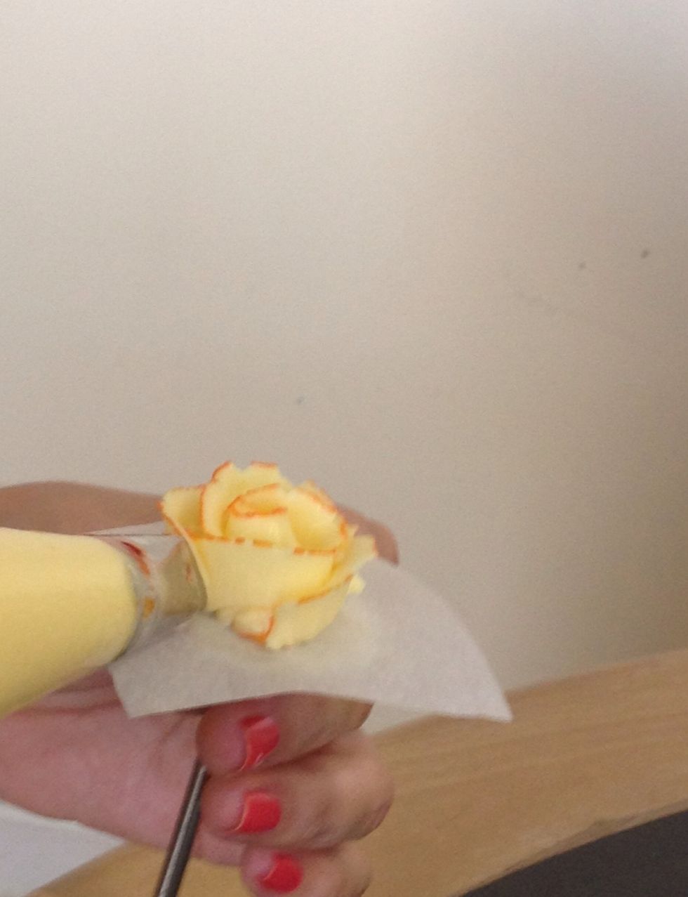 Make three petals around the base, angled upwards. Continue turning the nail and adding rows of petals.