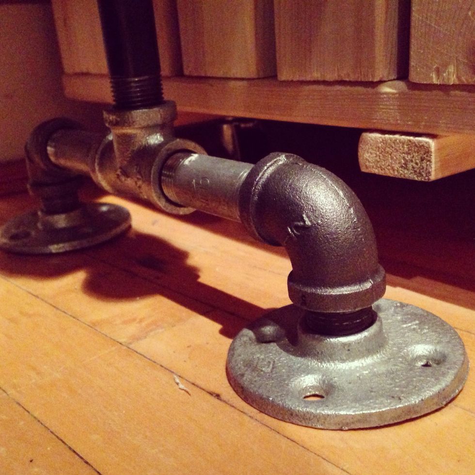 Make two bases. Each base should look like this and include: two flanges, two 1"x1/2" pipe nipple closes, two 2"x1/2" pipe nipple closes, two 1/2" elbows and one 1/2" tee fitting.