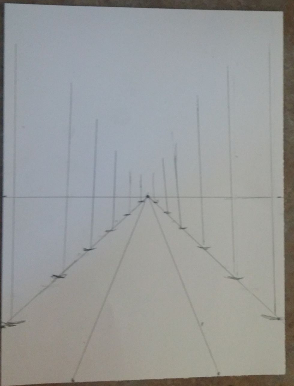 make vertical straight lines at each mark where the trunks of the trees will go. the trees closest are taller, the ones furthest away are shorter. They also form an upside down triangle.