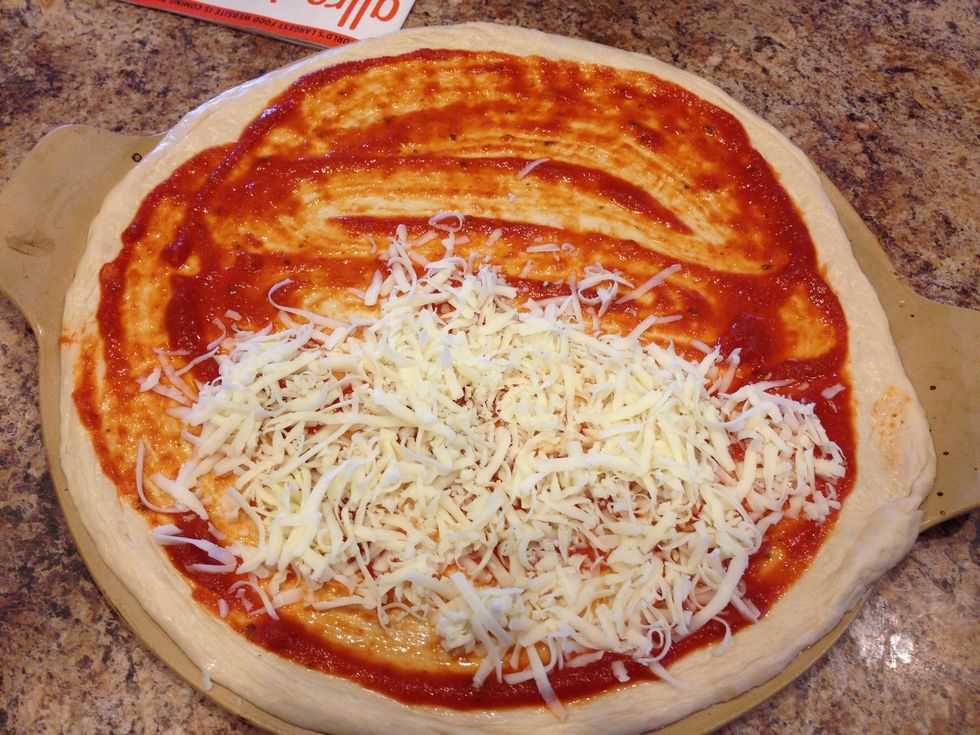 Make your own dough or purchase one at your favorite italian market. Let it rise and then roll out on your pizza stone.  Spread a thin layer of marinara sauce, leaving about 1/2 inch for the crust.