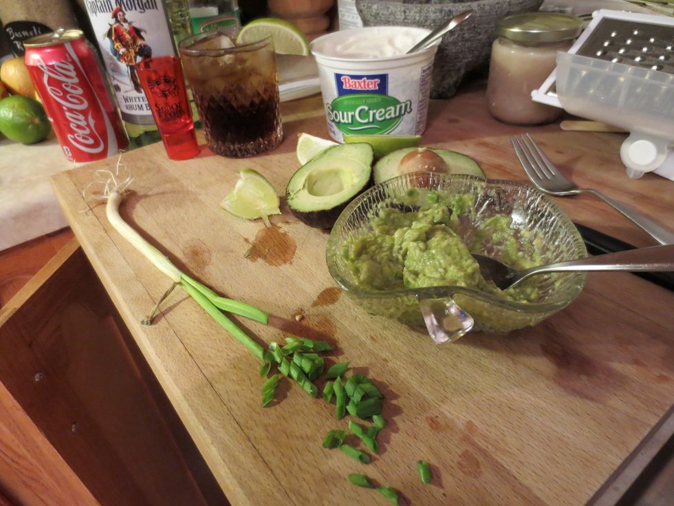 Making garnish! Some guacamole, chop green onion, slice lime. Used some of the lime for my Cuba Libre. Half your avocado, remove pit, scoop, add a squeeze of lime and a pinch of salt, mash with fork.