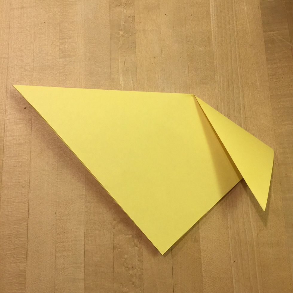 Making sure the long folded side of the triangle is at the top, take one of the points and fold it down slightly past the diagonal edge.