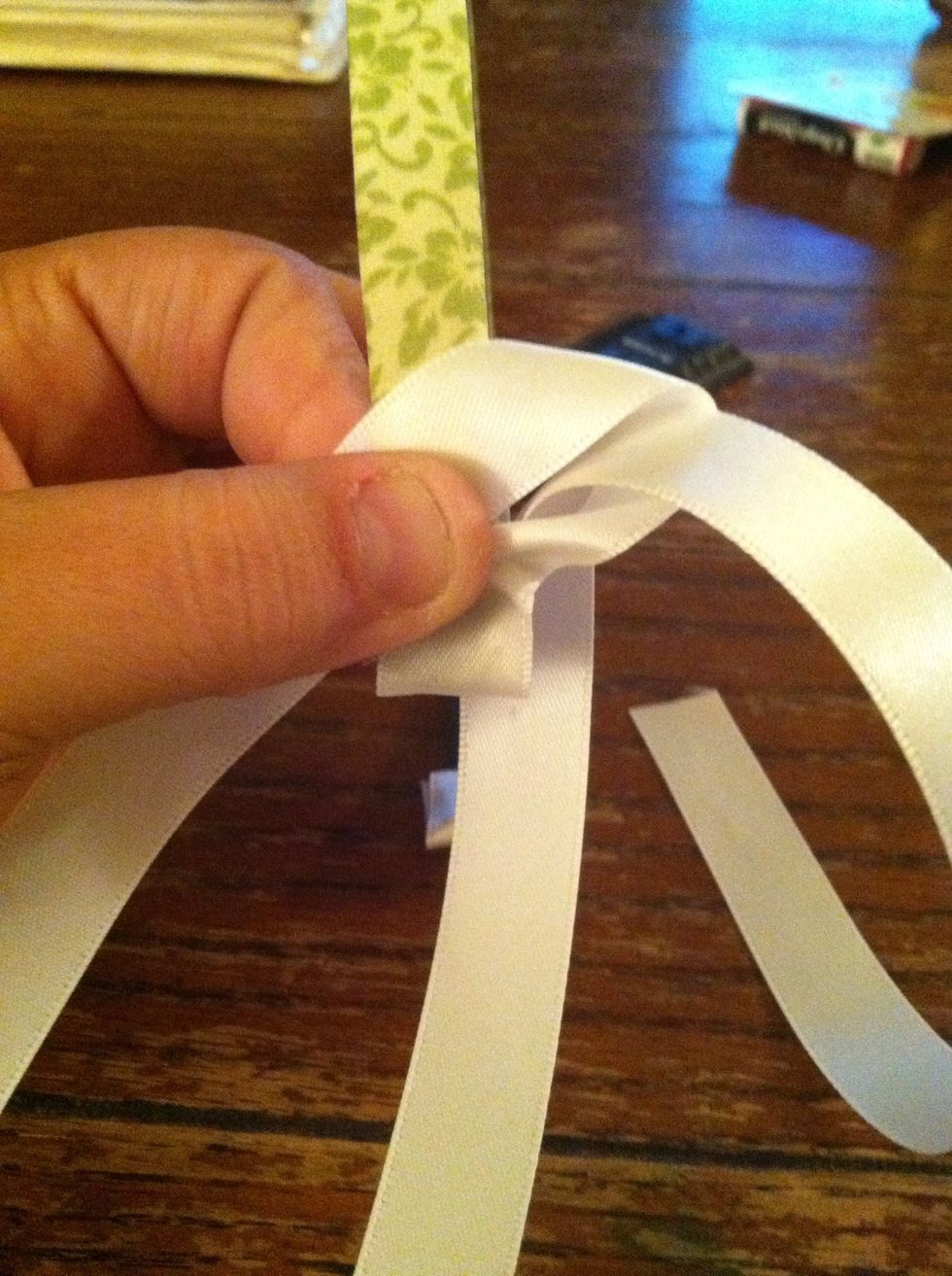 Making sure the loop is in FRONT bring the ribbon around the BACK and Thread the end of the ribbon through the loop.