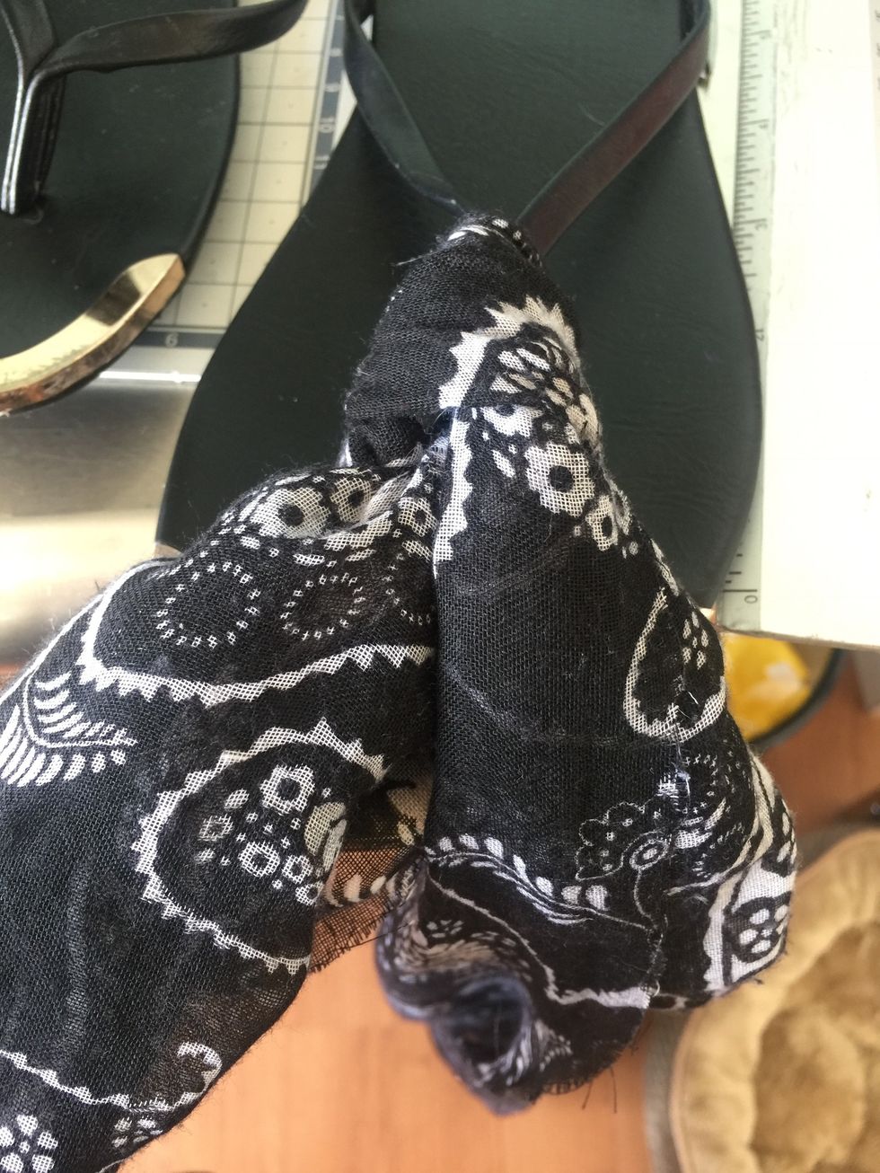 Making the knot in front of the sandal pull through