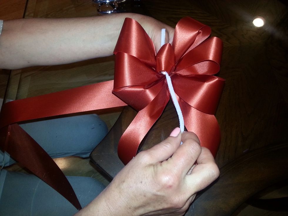 Making the tail: swing a long loop over for the tail Put pipe cleaner inside the center loop & under the tail & twist