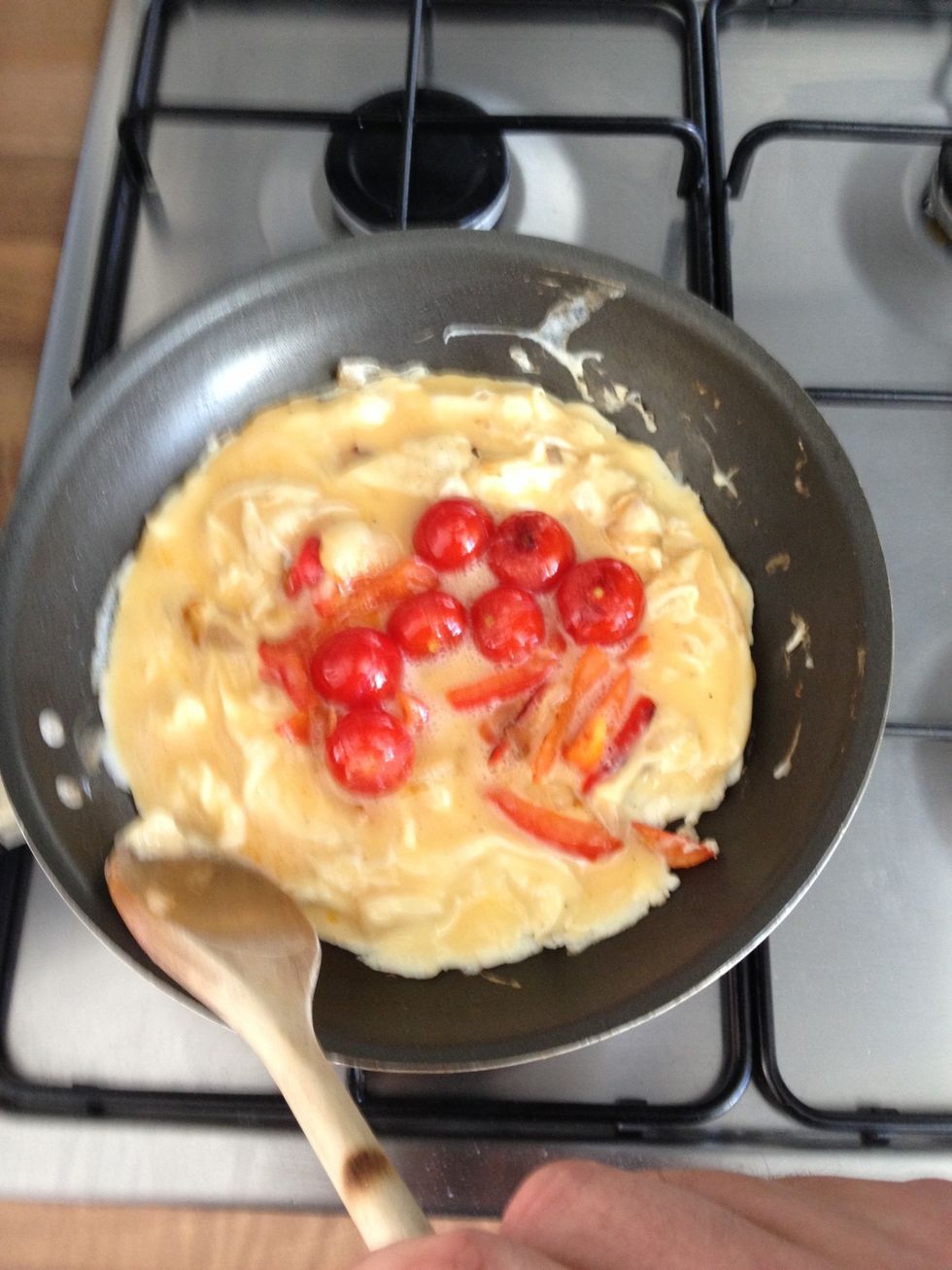 Manipulate the edges of the mixture so that the forming omelette doesn't burn.