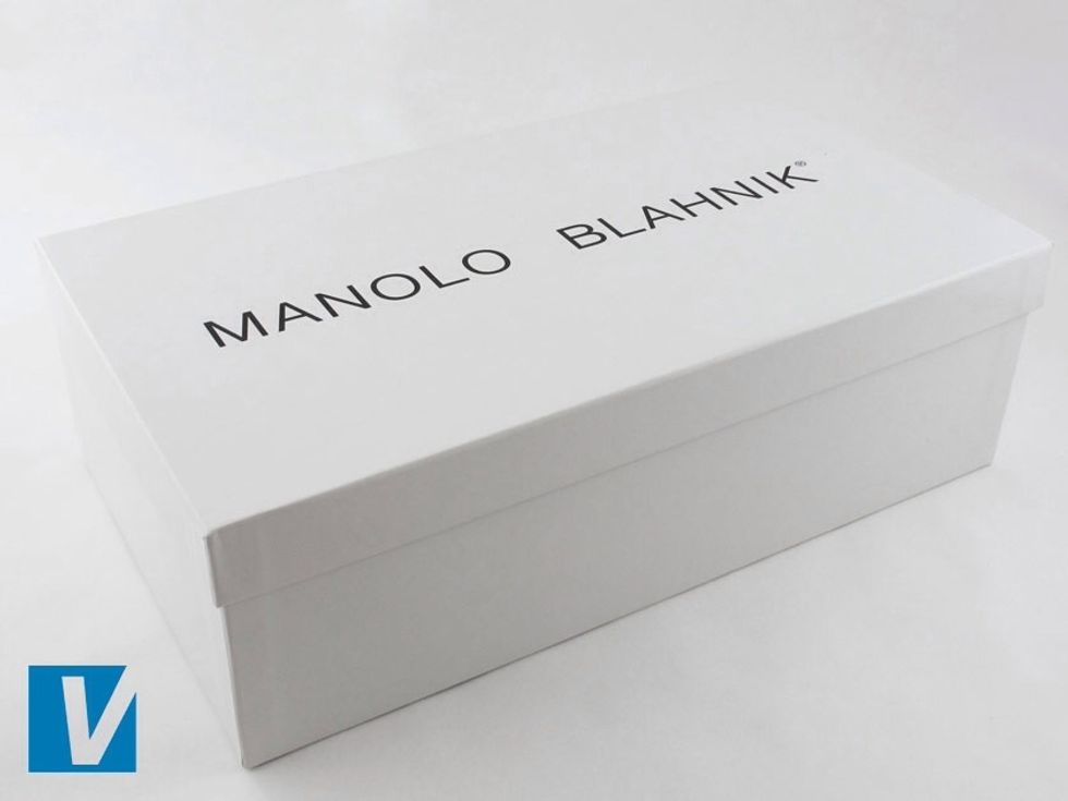 Manolo Blahnik shoes are packaged in a strong white box that features the 'MANOLO BLAHNIK' logo across the middle. The registered trademark circled R is also present.