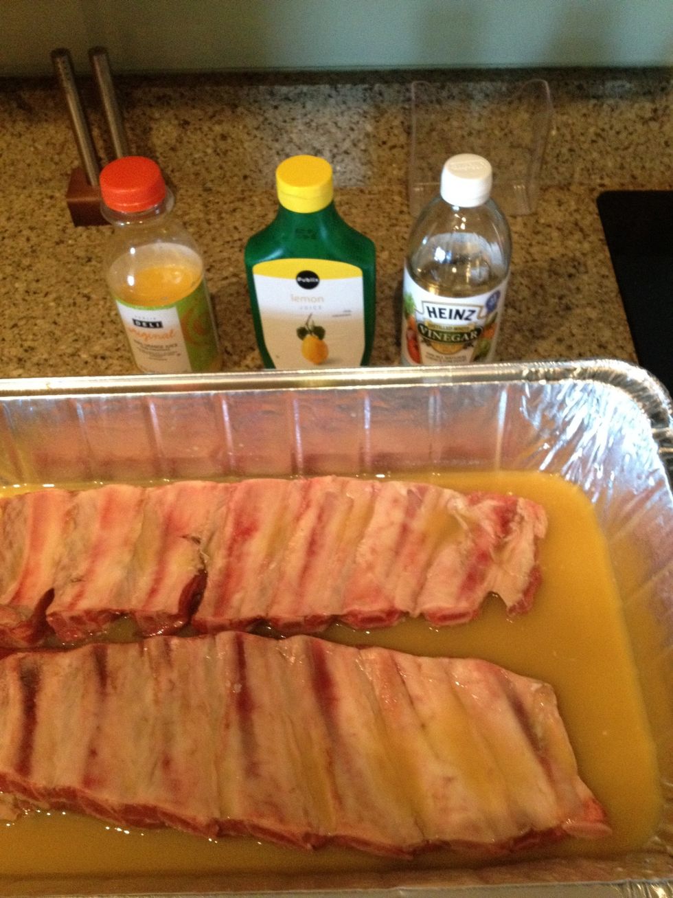 Marinate ribs to make them tender. Use half of orange juice, 4 oz of both lemon juice and white vinegar. Refrigerate overnight.