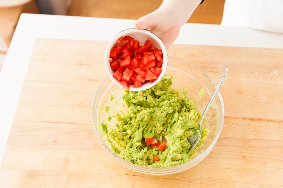 Mash avocados in a large bowl. Add diced tomato.