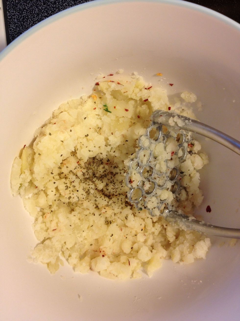 Mash potatoes; add salt, chili flakes, oregano, egg and flour.  Mix with fork or spoon