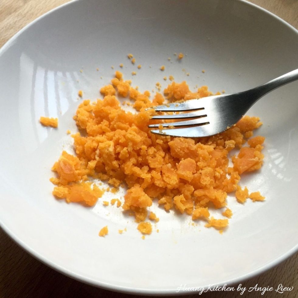 Mash the cooked egg yolks while still hot and set aside.