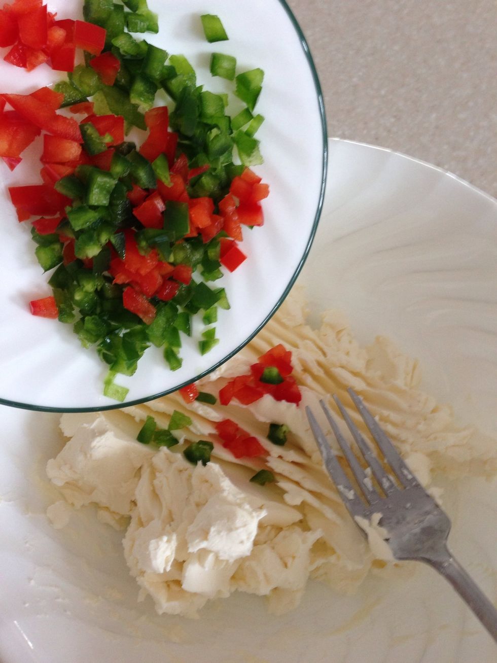 Mash up the brick of cream cheese (1 cup) until it has a bit of give to it. Add chopped up peppers