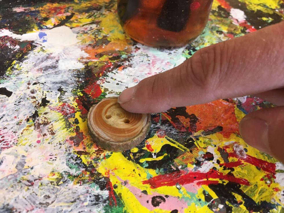 Massera in oljan p\u00e5 hela knappen med fingrarna.