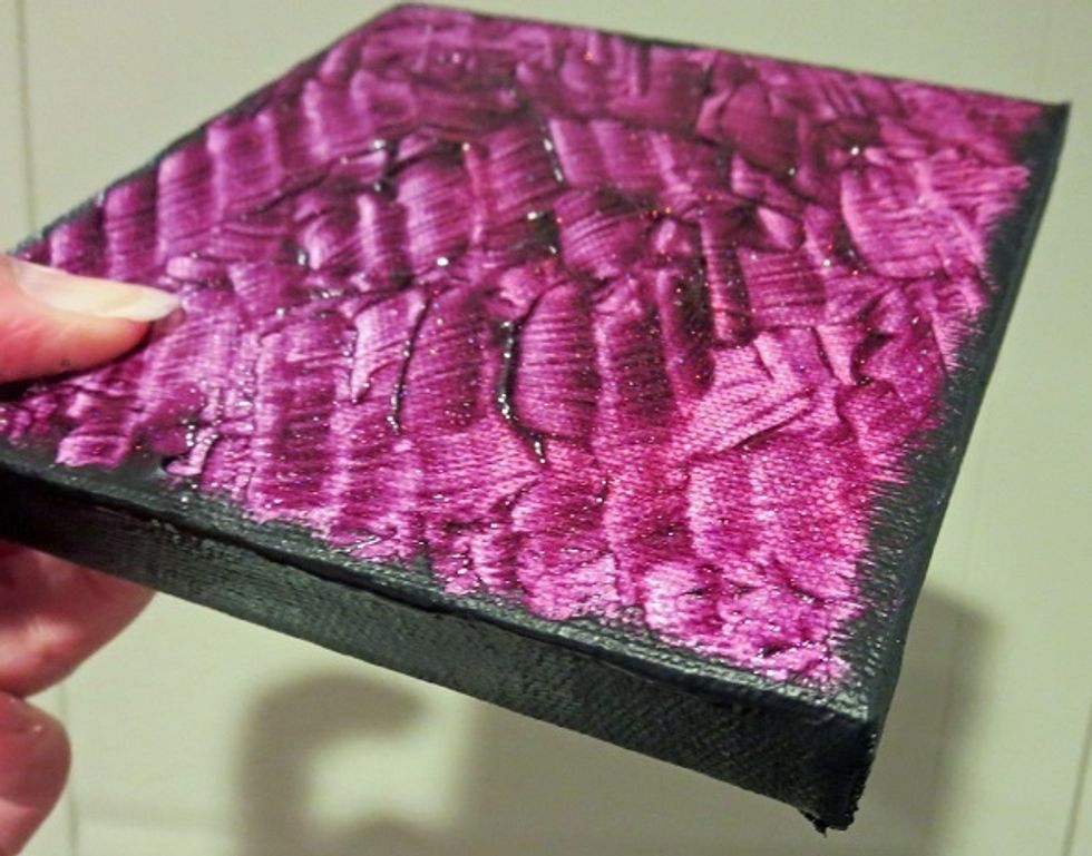 Matte black acrylic paint is added to the outer edge of the canvas.