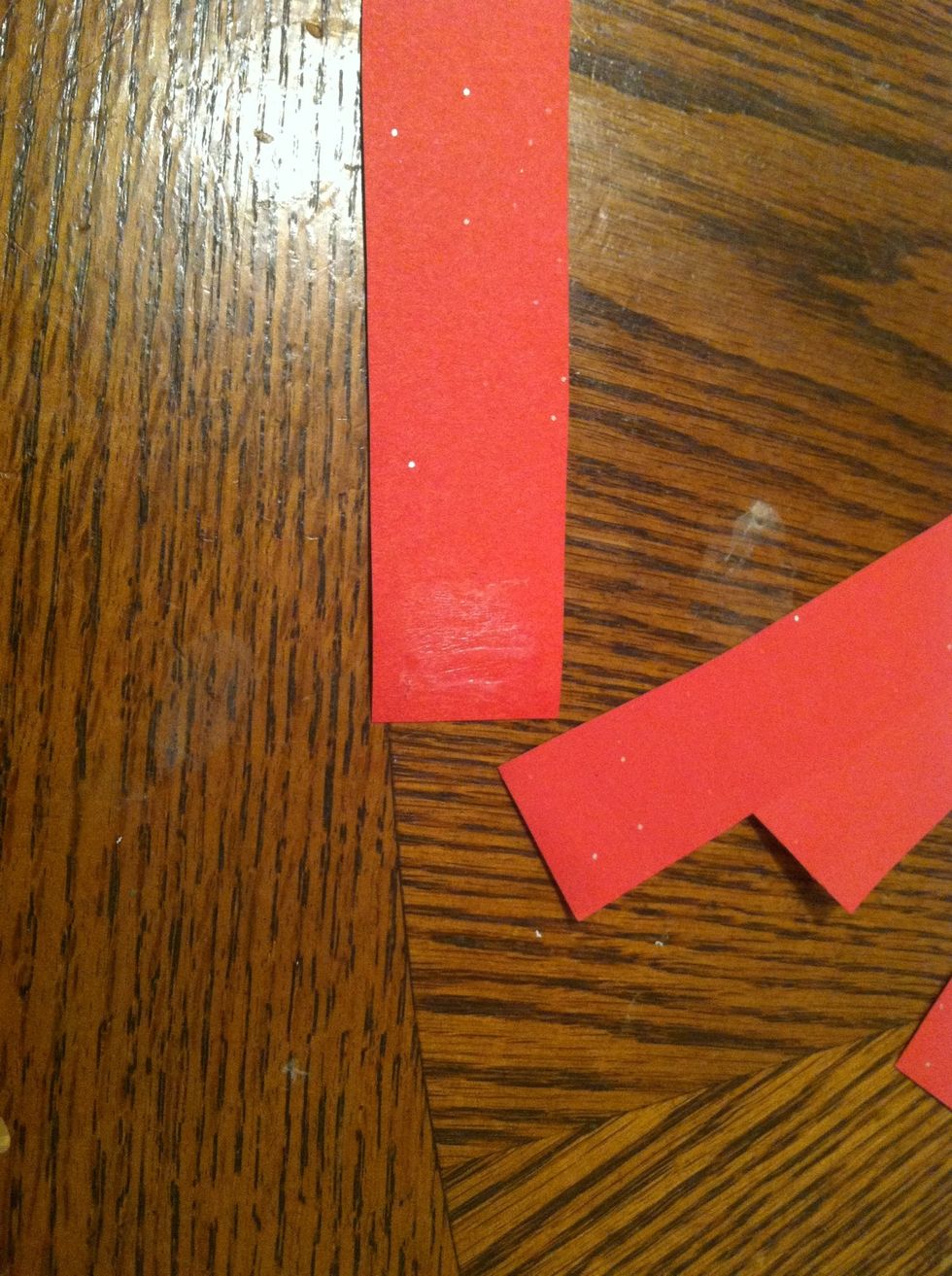 Mean while, use the left over strips of Red to make a bow. Add glue to one end, fold the paper over without creasing and press the ends together.
