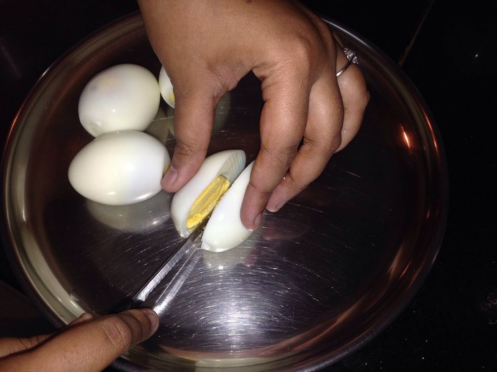 Meantime, take the boiled eggs and cut them into half.