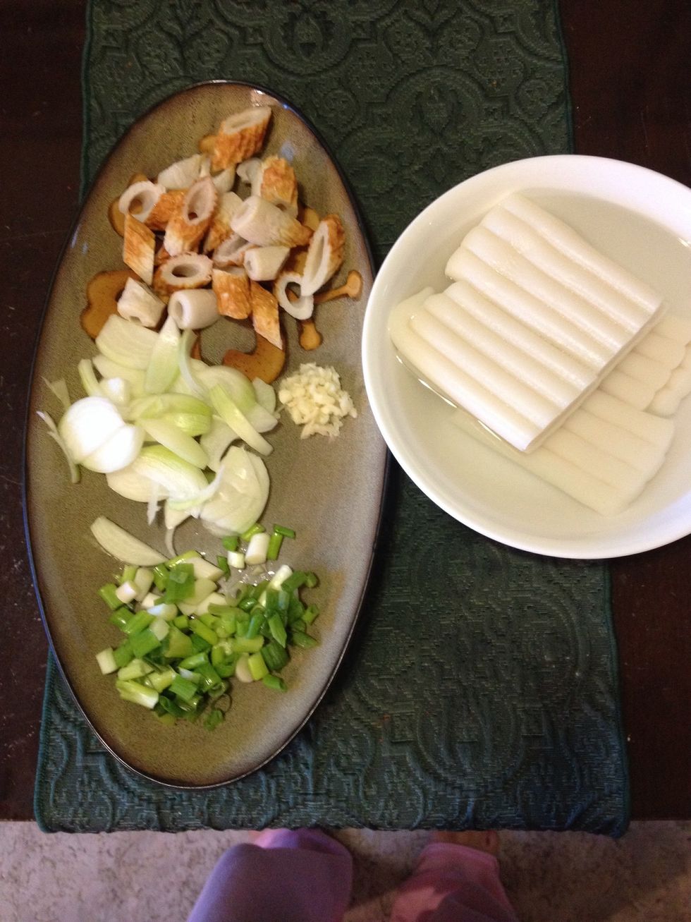 Meanwhile, chop all the ingredients and prepare. Put all the sticky rice cakes in warm water so that they become softer in texture. After a while, separate the rice cakes and put them aside.